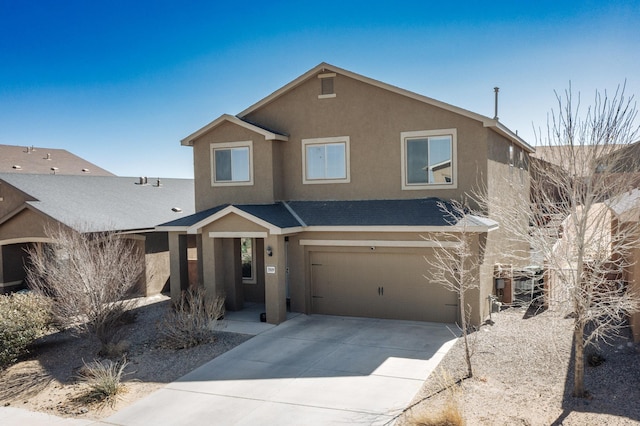 view of front of property featuring concrete driveway, an attached garage, and stucco siding