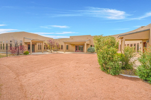 back of property featuring stucco siding, fence, and a patio area