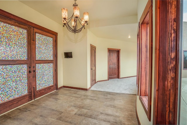 foyer entrance with an inviting chandelier, french doors, and baseboards