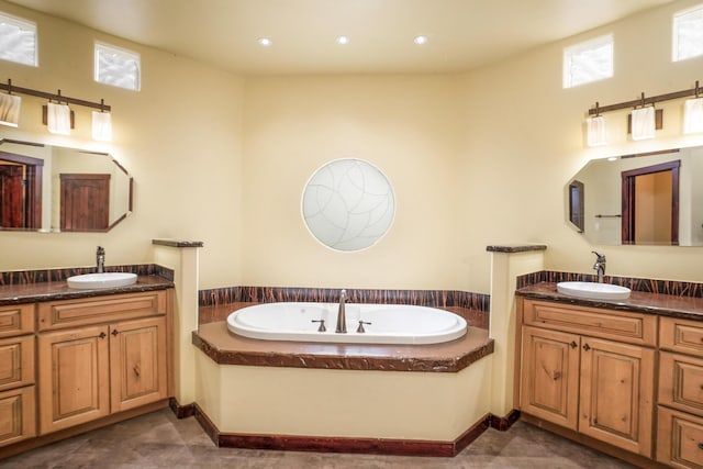 full bathroom featuring recessed lighting, two vanities, a garden tub, and a sink