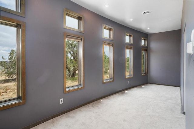 spare room featuring carpet flooring, baseboards, and visible vents