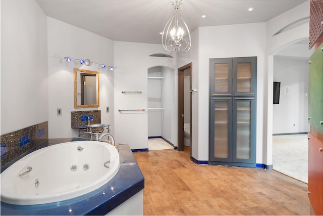 full bathroom featuring baseboards, an inviting chandelier, recessed lighting, a whirlpool tub, and toilet