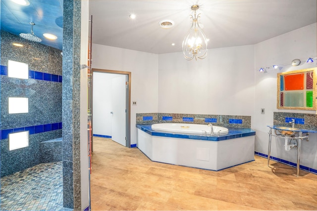 full bath featuring visible vents, a garden tub, a stall shower, and an inviting chandelier