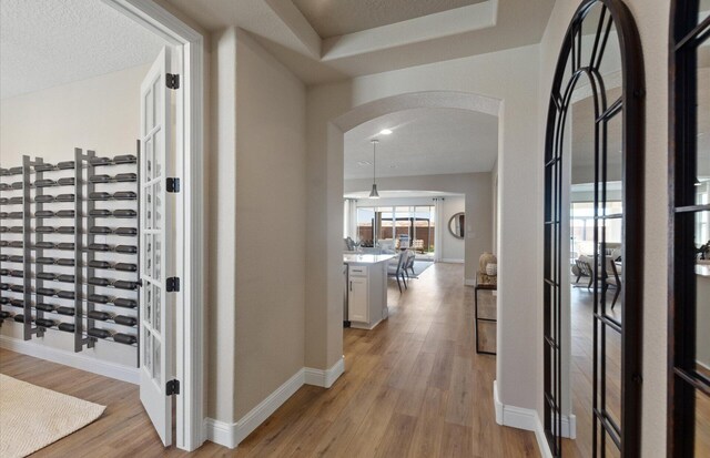 938 Lazuli Rd SE, Rio Rancho, NM 87124 - wine area with light wood-style floors, arched walkways, and baseboards