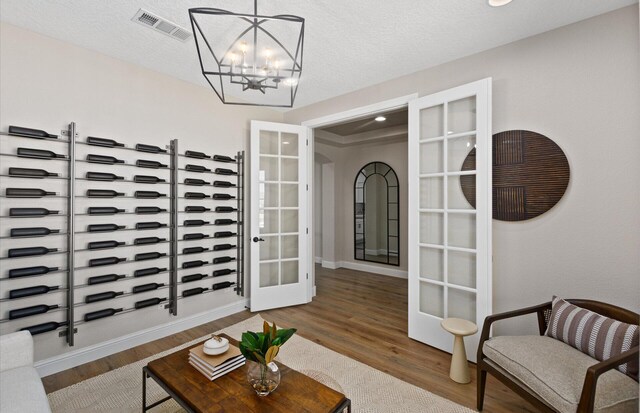 938 Lazuli Rd SE, Rio Rancho, NM 87124 - living area featuring wood finished floors, visible vents, french doors, a textured ceiling, and a notable chandelier