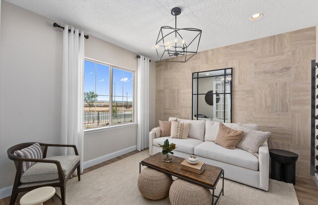 938 Lazuli Rd SE, Rio Rancho, NM 87124 - living room with a notable chandelier, wood finished floors, baseboards, and a textured ceiling