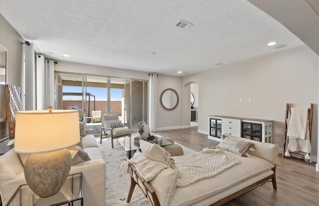 938 Lazuli Rd SE, Rio Rancho, NM 87124 - living room featuring arched walkways, visible vents, baseboards, and wood finished floors