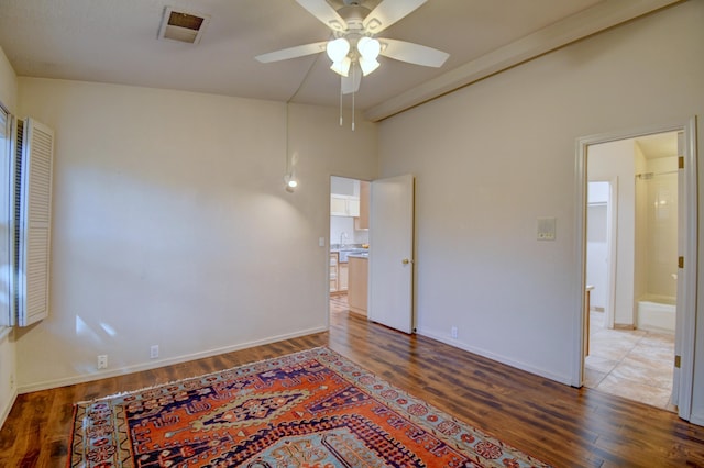 spare room with baseboards, visible vents, a ceiling fan, wood finished floors, and a sink