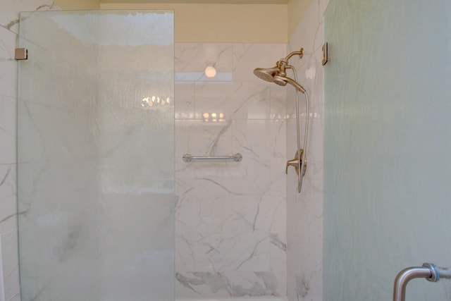 bathroom featuring a marble finish shower