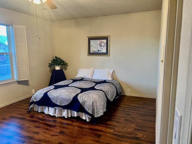 bedroom with baseboards and wood finished floors