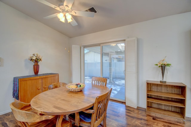 dining space with baseboards, visible vents, ceiling fan, and wood finished floors