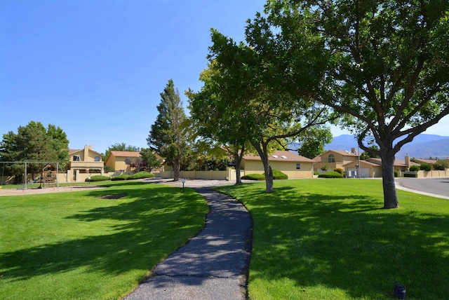 view of home's community with a lawn and playground community