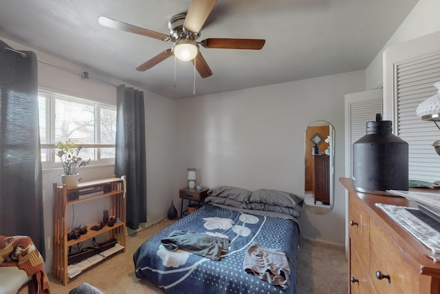 bedroom with a ceiling fan and light colored carpet