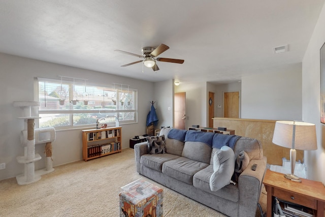 carpeted living area with visible vents and a ceiling fan