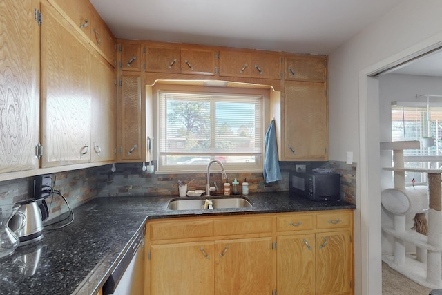 kitchen featuring tasteful backsplash, stainless steel dishwasher, a sink, dark stone countertops, and black microwave