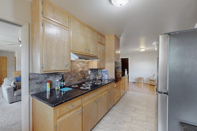 kitchen with decorative backsplash, a ceiling fan, dark stone countertops, under cabinet range hood, and black appliances