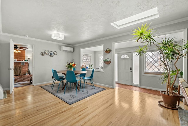 dining room featuring ornamental molding, wood finished floors, and a wall mounted AC