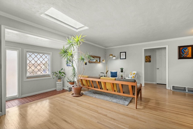 entrance foyer featuring a skylight, visible vents, crown molding, and wood finished floors