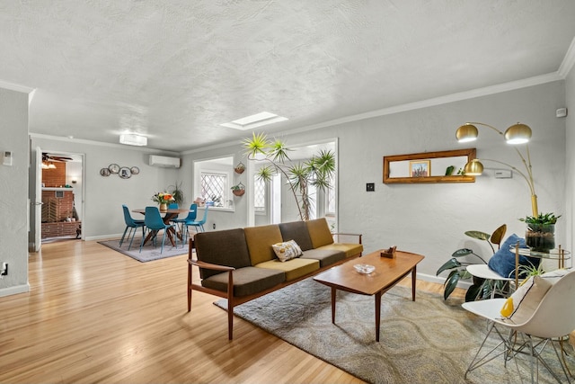 living area featuring a textured ceiling, a wall mounted AC, ornamental molding, and light wood-style floors
