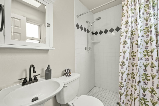 bathroom with toilet, a shower stall, and a sink