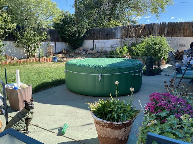 view of patio / terrace featuring a fenced backyard and a hot tub