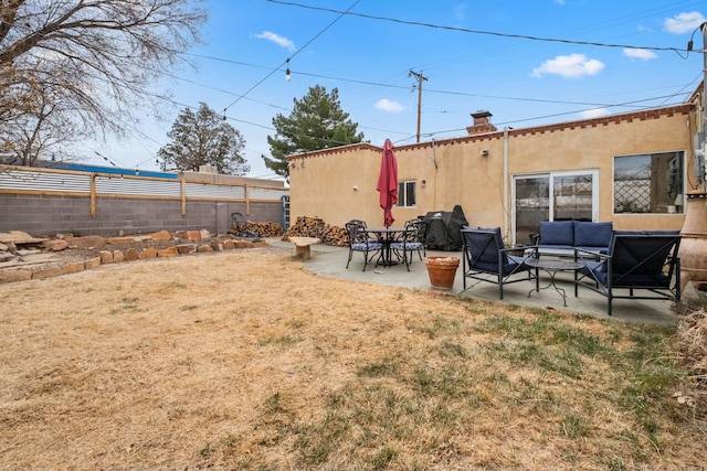 rear view of property featuring a yard, a chimney, stucco siding, a patio area, and fence