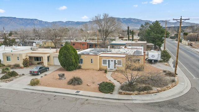 view of front of house featuring a garage, a mountain view, and stucco siding