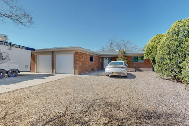 single story home featuring concrete driveway, brick siding, and an attached garage