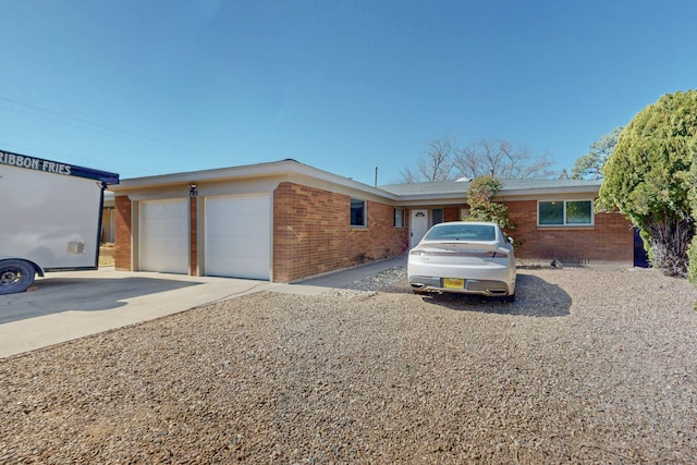 ranch-style house featuring brick siding, driveway, and an attached garage