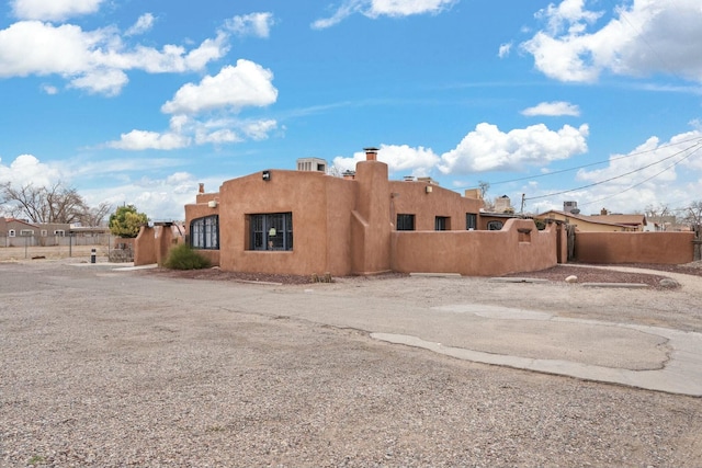 back of house featuring a fenced front yard and stucco siding