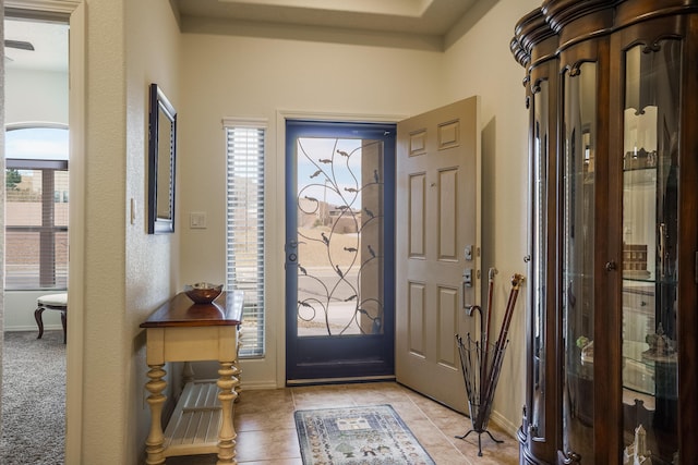 foyer entrance featuring light tile patterned floors and baseboards