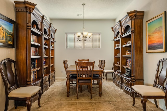 dining area featuring an inviting chandelier, light tile patterned flooring, baseboards, and a textured ceiling