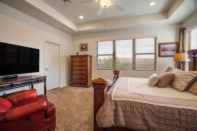 bedroom with a raised ceiling, a ceiling fan, baseboards, and carpet floors