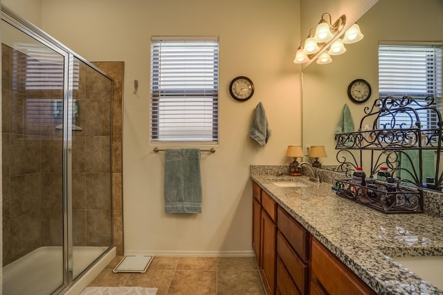 full bathroom featuring tile patterned flooring, a shower stall, baseboards, double vanity, and a sink