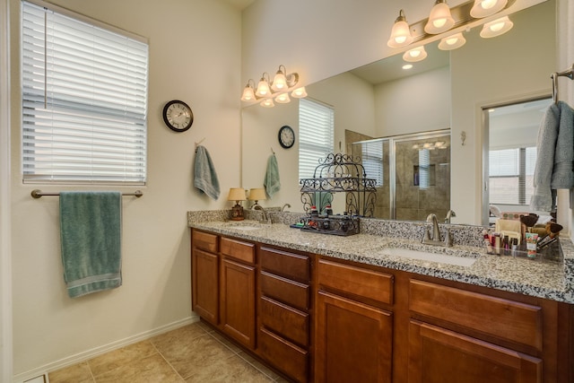 full bathroom with double vanity, tile patterned floors, a stall shower, and a sink