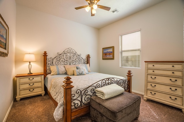 bedroom featuring visible vents, baseboards, a ceiling fan, and dark carpet