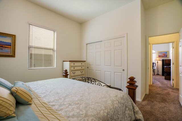 carpeted bedroom featuring a closet and baseboards