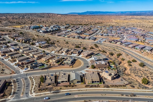 drone / aerial view featuring a residential view, a mountain view, and view of desert