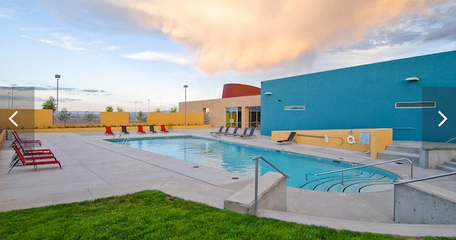 community pool featuring fence and a patio area