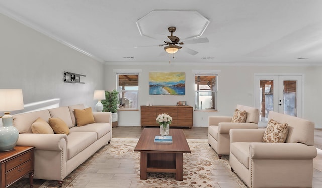 living area featuring french doors, a healthy amount of sunlight, crown molding, and visible vents