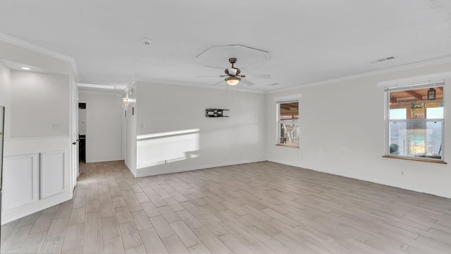 unfurnished room with ceiling fan, ornamental molding, visible vents, and light wood-style flooring