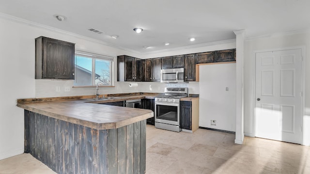 kitchen with stainless steel appliances, visible vents, a sink, dark brown cabinets, and a peninsula