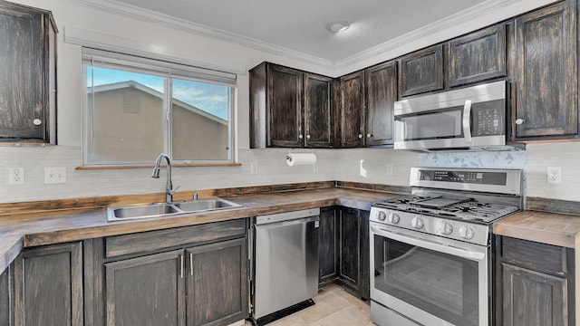 kitchen featuring tasteful backsplash, appliances with stainless steel finishes, ornamental molding, a sink, and butcher block countertops