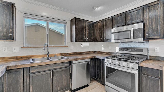 20 2nd St NE, Rio Rancho, NM 87124 - kitchen featuring crown molding, stainless steel appliances, backsplash, a sink, and wood counters