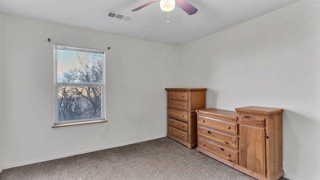 unfurnished bedroom featuring light carpet, baseboards, visible vents, and a ceiling fan