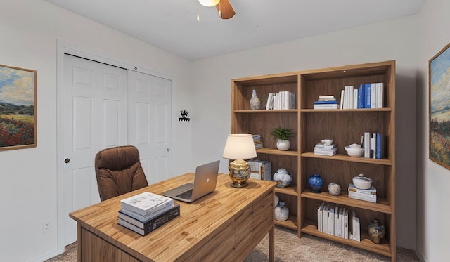 carpeted home office with a ceiling fan