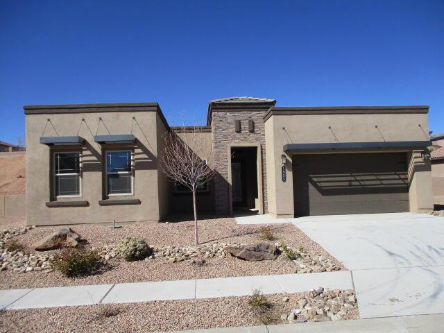 contemporary home with a garage, stone siding, driveway, and stucco siding