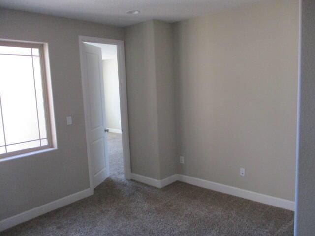 carpeted spare room with baseboards