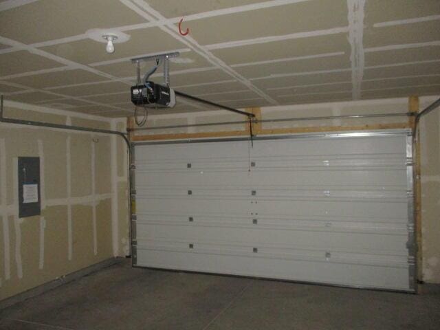 garage featuring electric panel and a garage door opener