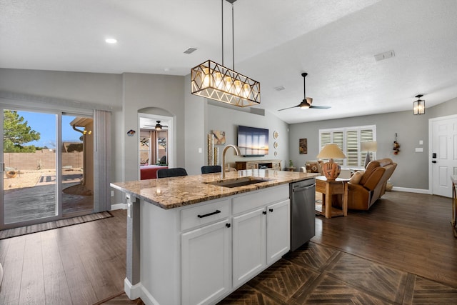 kitchen with dishwasher, ceiling fan, open floor plan, and a sink